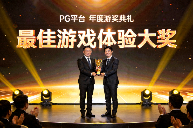 PG平台代表在年度颁奖典礼舞台上领取最佳游戏体验大奖的现场照片